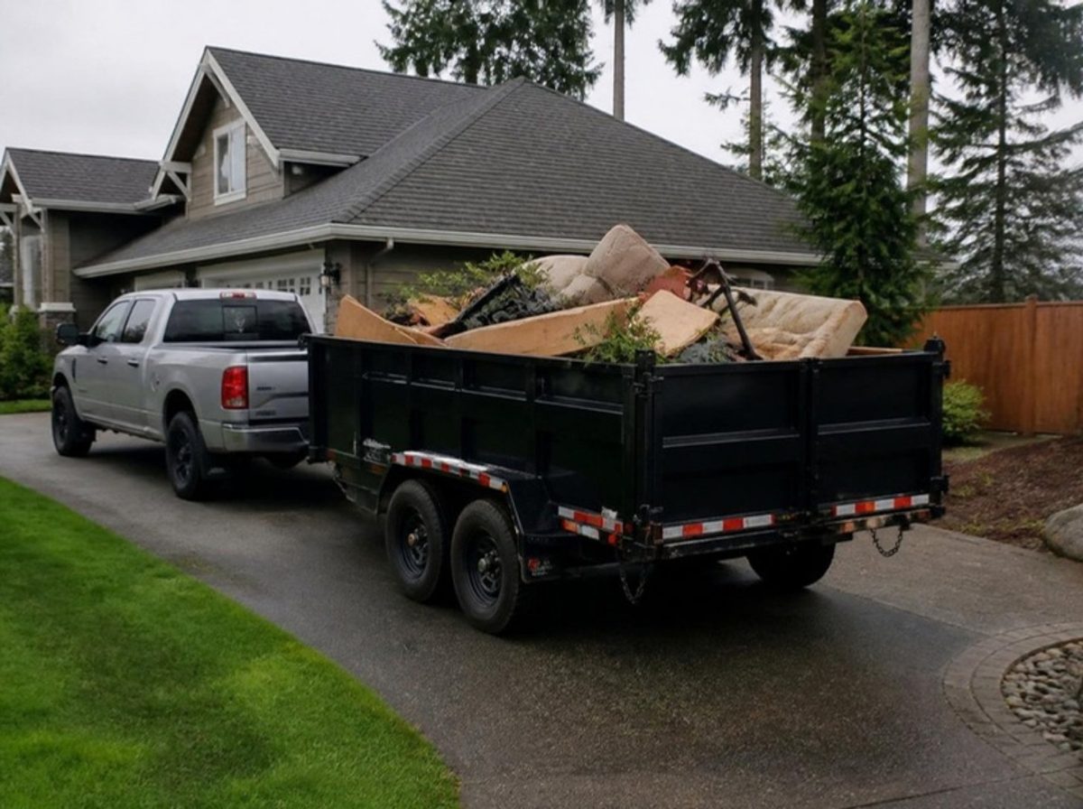 Truck and dump trailer loaded with old furniture and yard debris